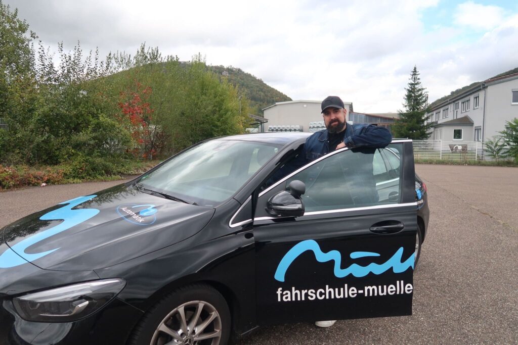 Fahrlehrer Ralph mit seinem Fahrschulauto