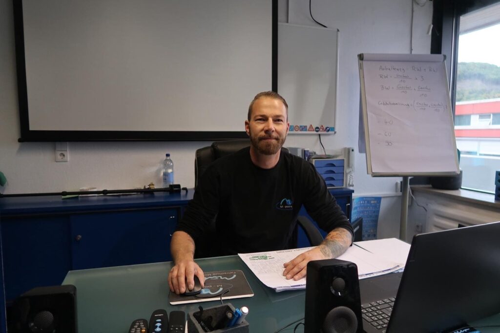 Fahrlehrer an einem Schreibtisch vor dem Theorieunterricht